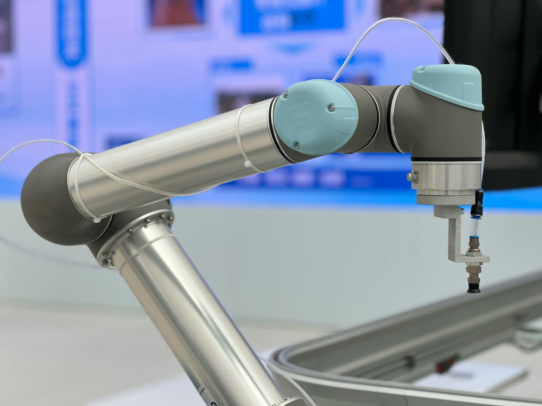 White industrial robot arm performing precise automated assembly task in bright clean facility